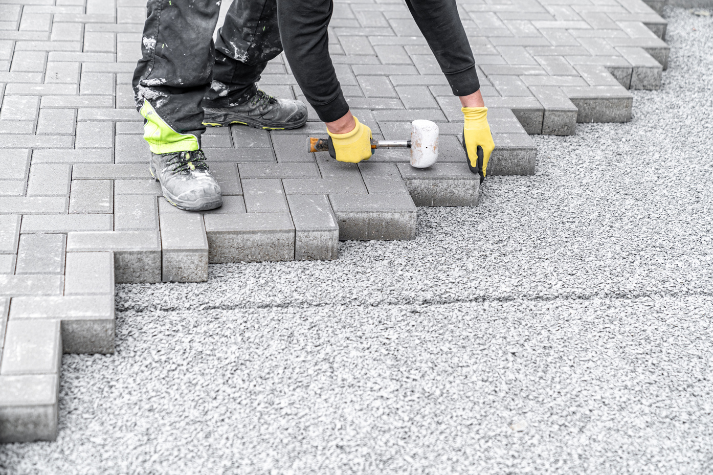 laying interlocking pavers during the construction of sidewalks and roads